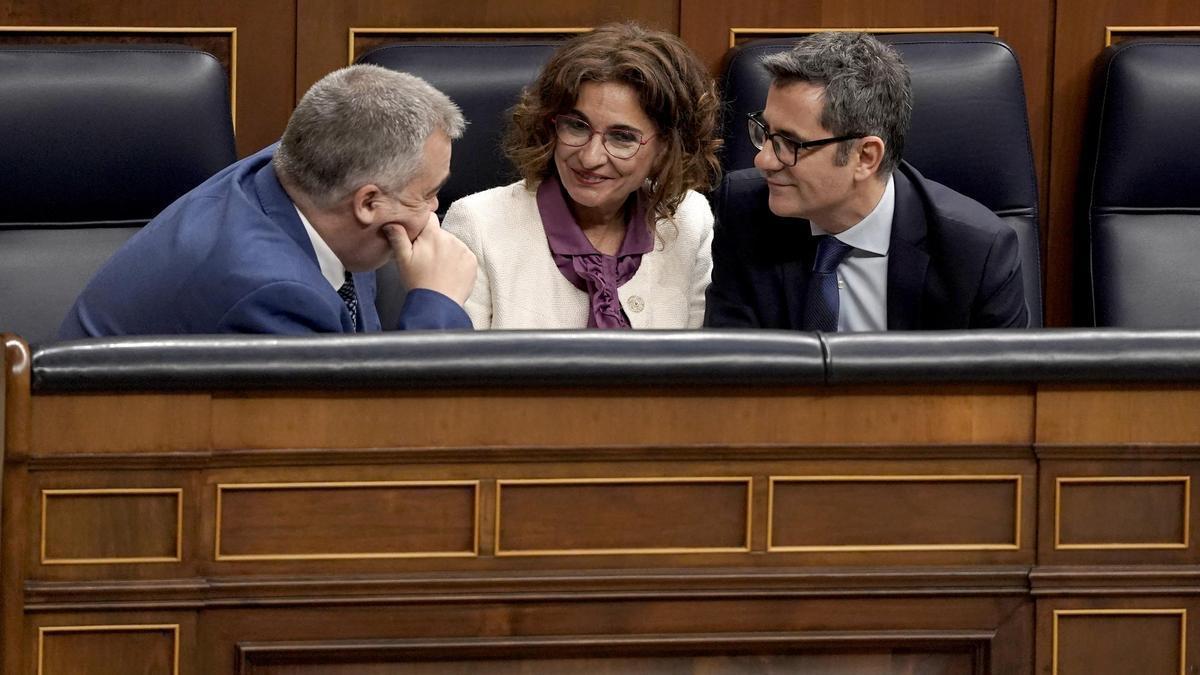 El número tres del PSOE, Santos Cerdán, la vicepresidenta primera, María Jesús Montero, y el ministro de Presidencia y Justicia, Félix Bolaños, durante el pleno de este martes sobre la amnistía.