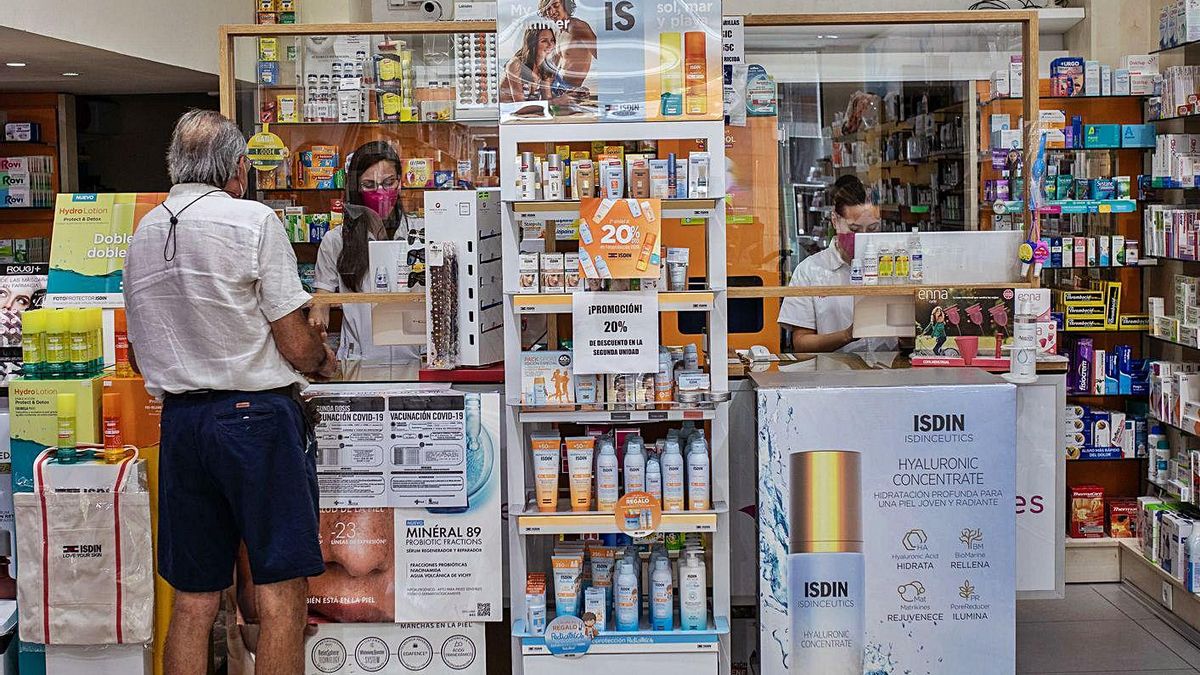 Un usuario compra medicamentos en una farmacia. | Emilio Fraile