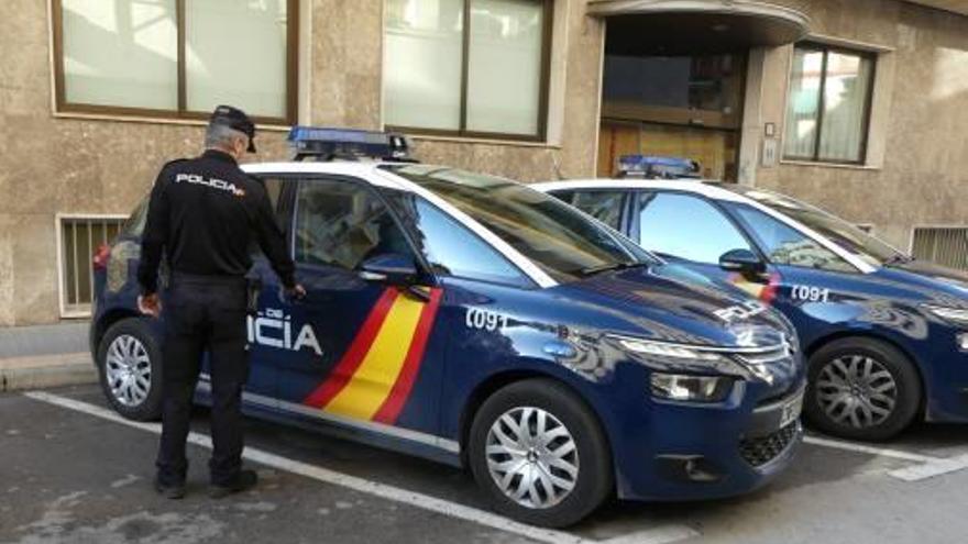 Un policía sube a un coche patrulla en la comisaría de Benidorm.