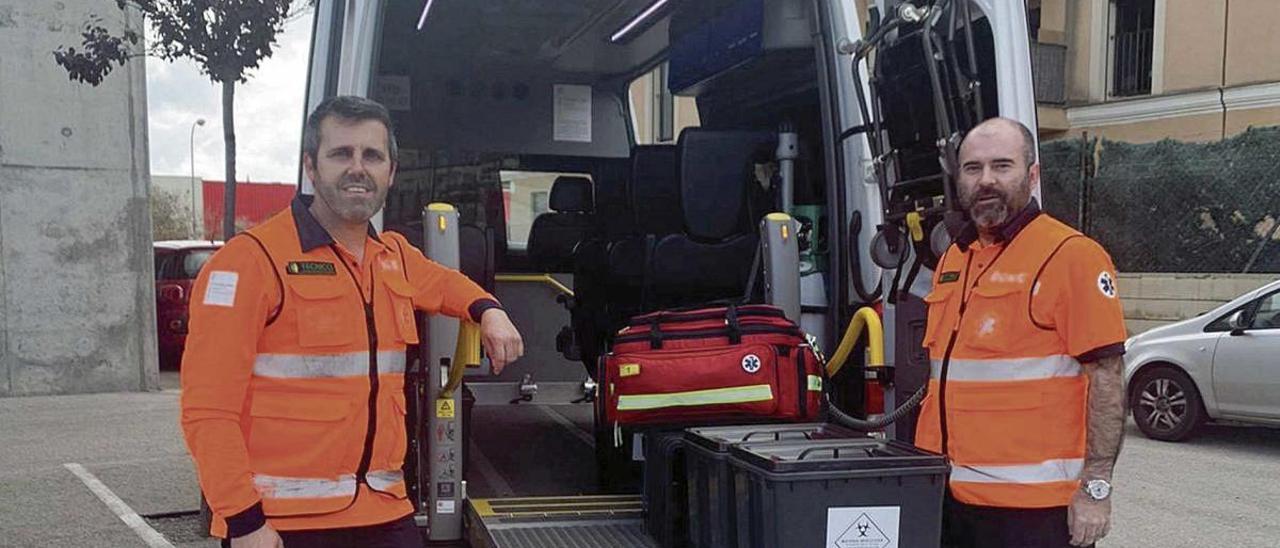 Dos técnicos de transporte sanitario posan junto a uno de los vehículos medicalizados utilizados por las UVAC.