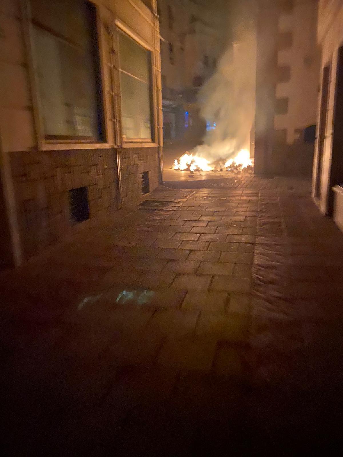 Contenedores ardiendo en la plaza Quemada, en el centro de Plasencia.