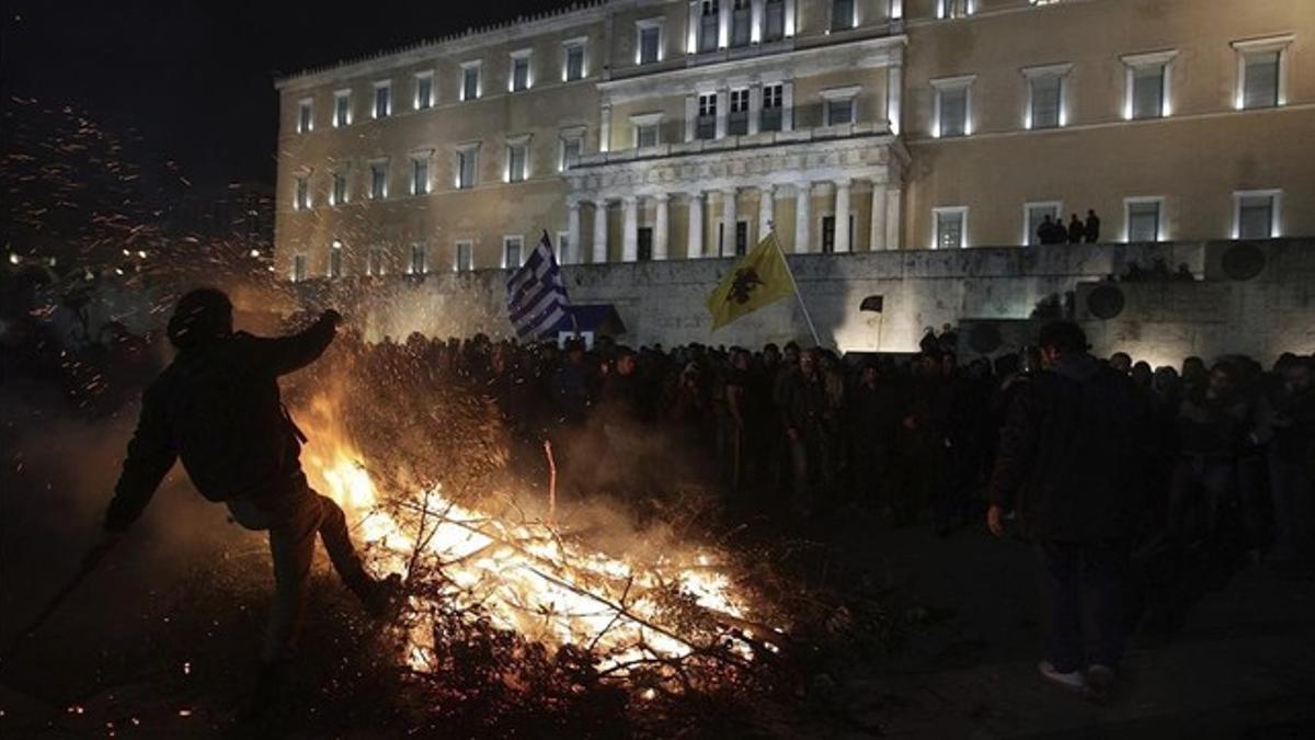 Ganaderos y agricultores queman ramas de olivos durante una manifestación frente al Parlamento, en Atenas, este viernes.