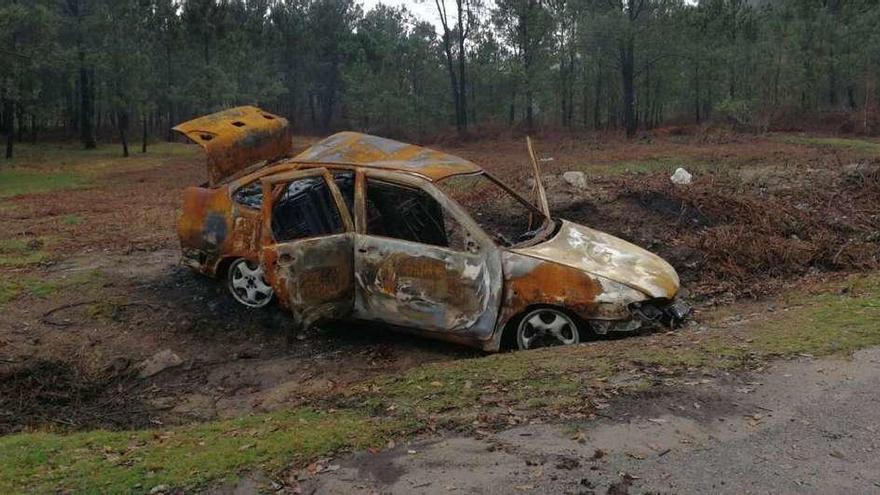 El coche calcinado en la entrada al área recreativa de Chans, en Cela. // Santos Álvarez