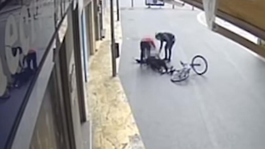 El ciclista y un testigo auxilian al herido.