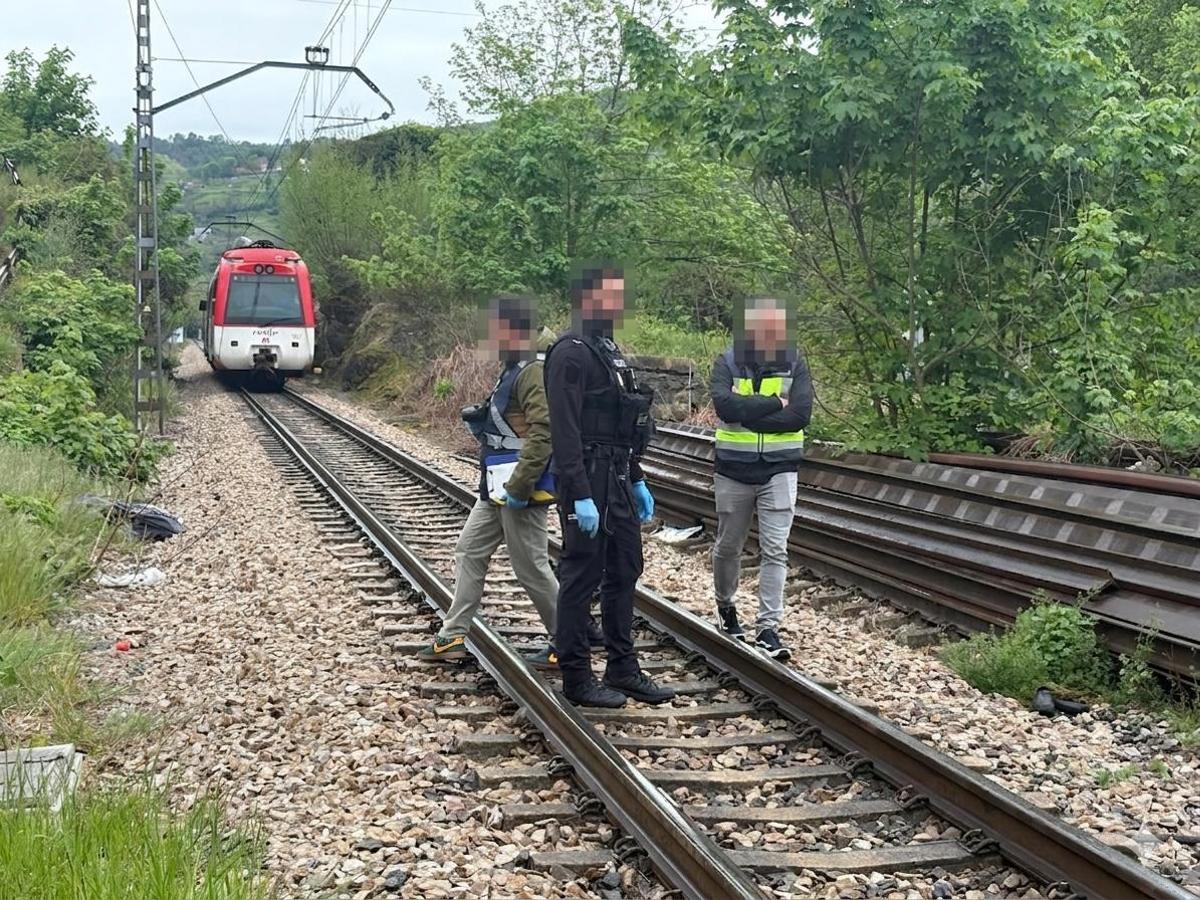 Policías en la vía del tren con el convoy al fondo