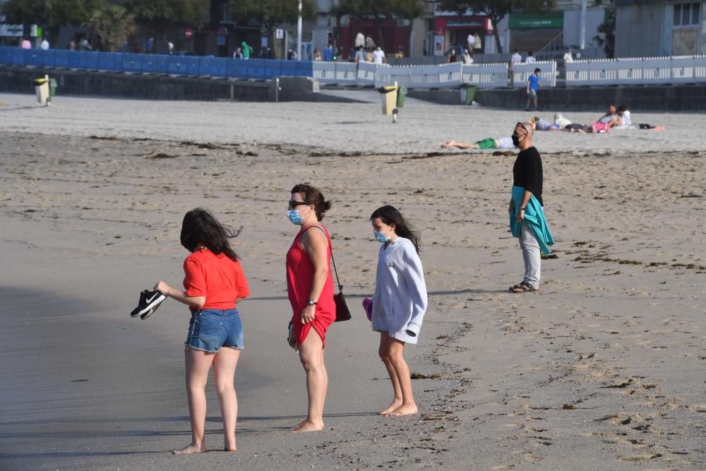 Los coruñeses que se acercan a las playas cumplen con la obligación de usar la mascarilla salvo para entrar en el agua.