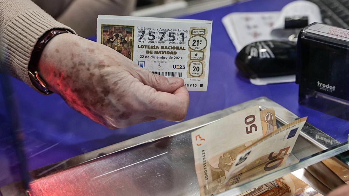 Una persona compra un décimo de Navidad en una administración de Loterías de Barcelona.