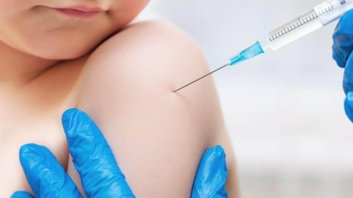 Un niño recibe una dosis de la vacuna triple vírica.