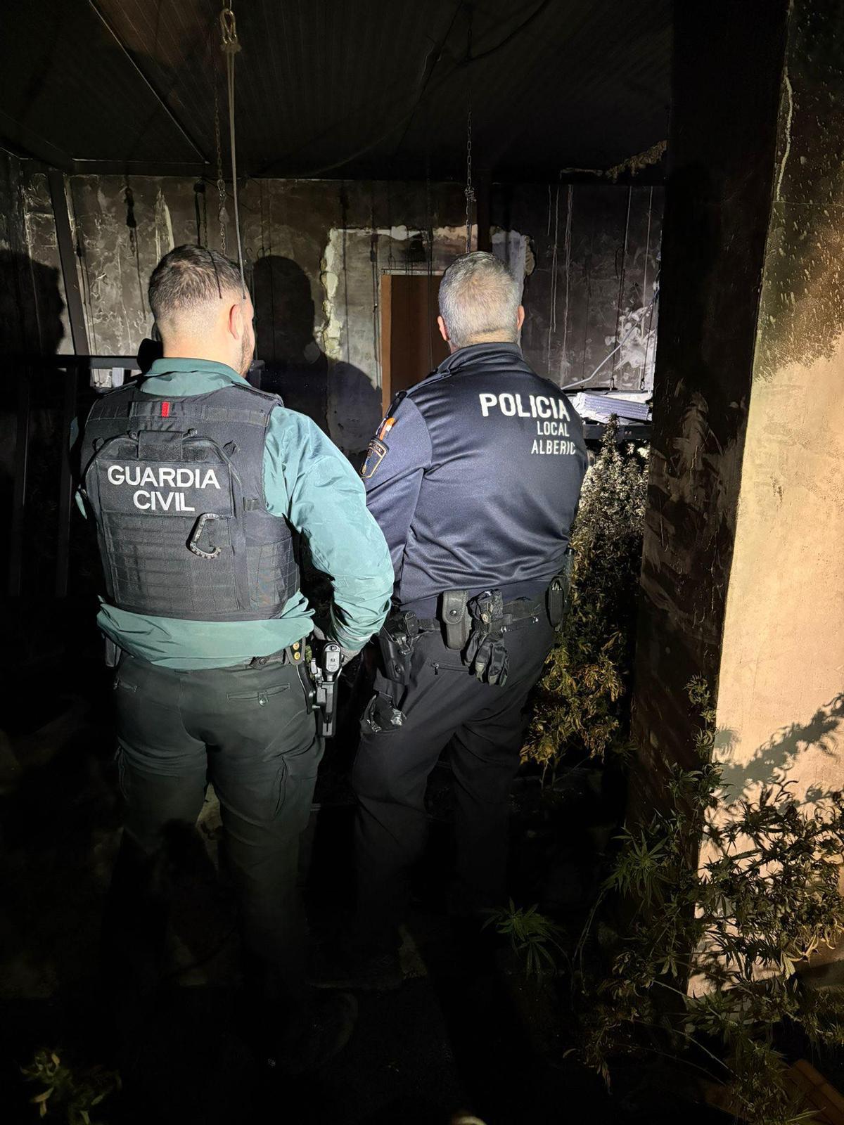 Agentes de la Guardia Civil y la Policía Local observan la plantación descubierta.