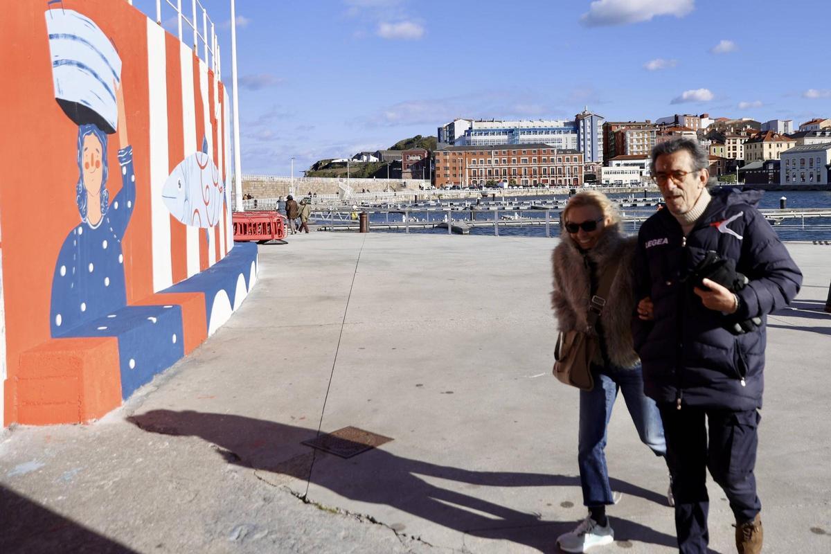 Personas paseando junto al mural de la punta de Lequerica.