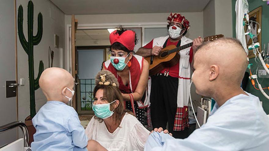 Dos niños reciben en su habitación del Hospital General de Alicante la visita de dos de los integrantes de Payasospital