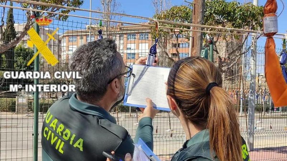 Dos agentes de la Guardia Civil inspeccionan un artefacto pirotécnico.