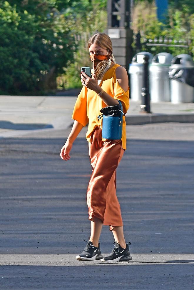 Olivia Palermo con falda midi satinada y zapatillas