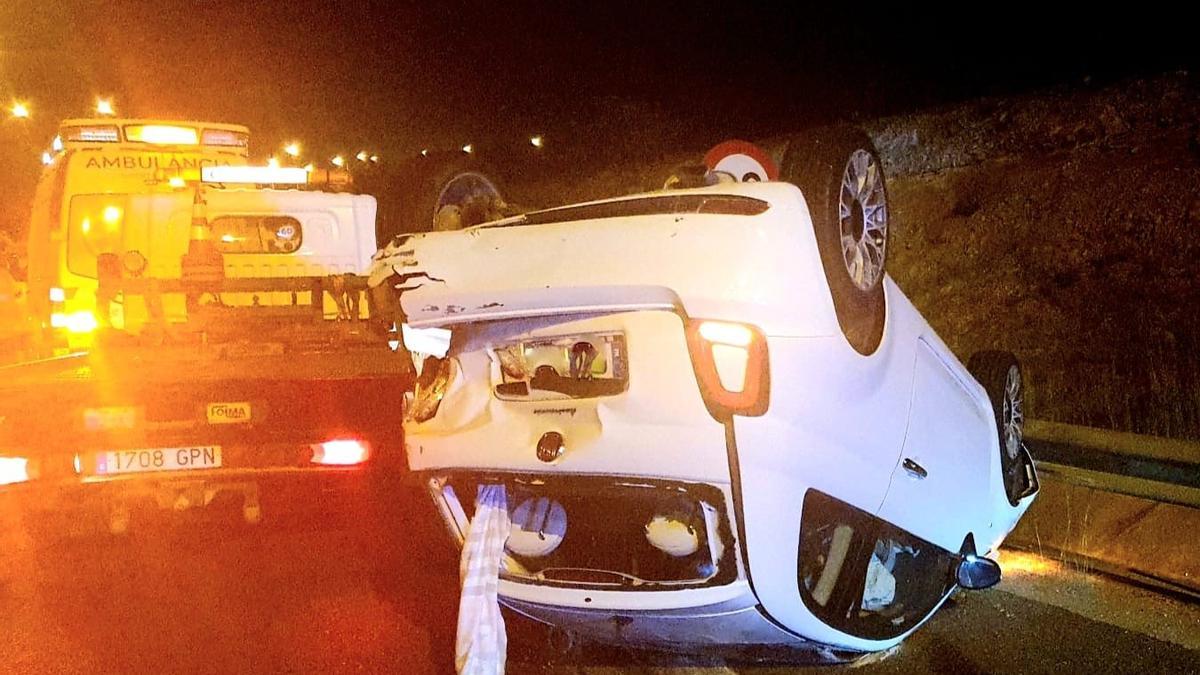 El Fiat 500 volcado tras el accidente de tráfico en la carretera del aeropuerto