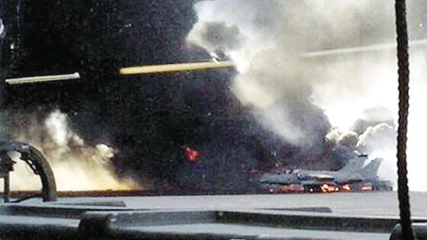 Las llamas del incendio y aviones contra los que chocó la aeronave en la pista de Los Llanos.