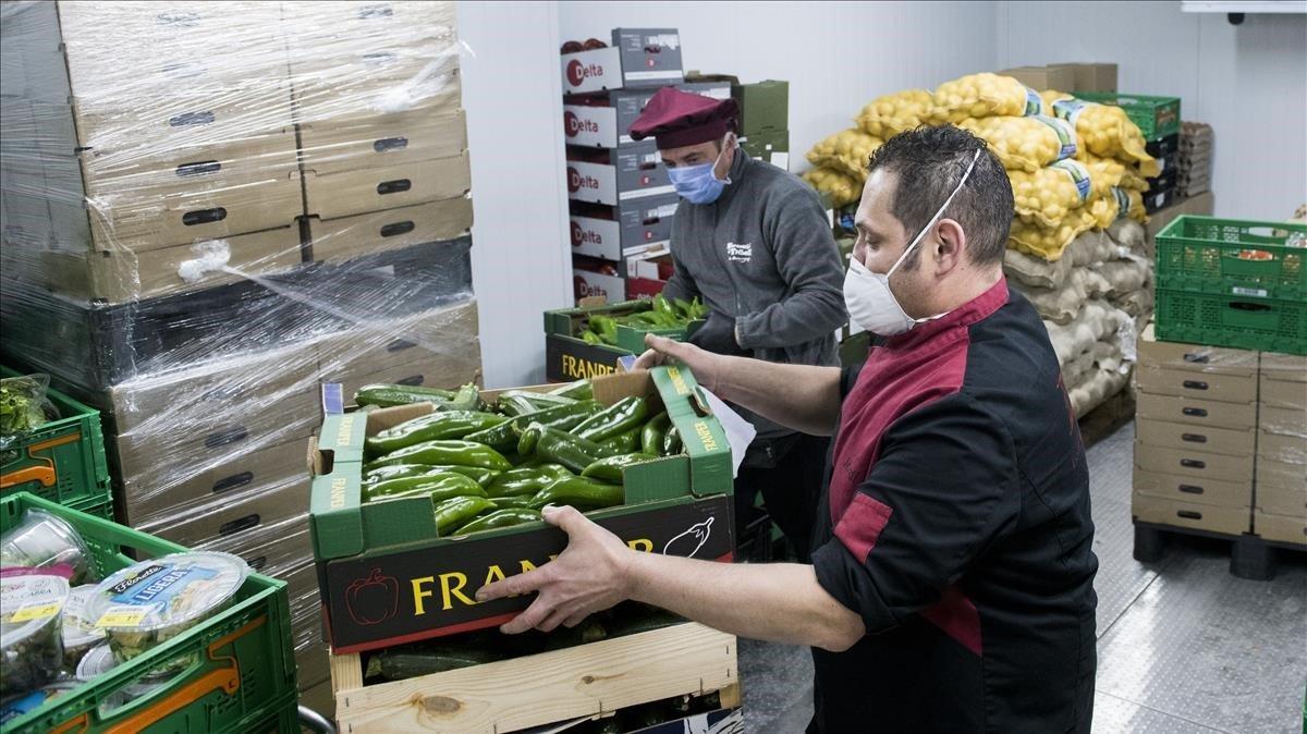 Jordi e Ignasi distribuyen las cajas de verduras frescas en el almacén de FiT, en Barcelona