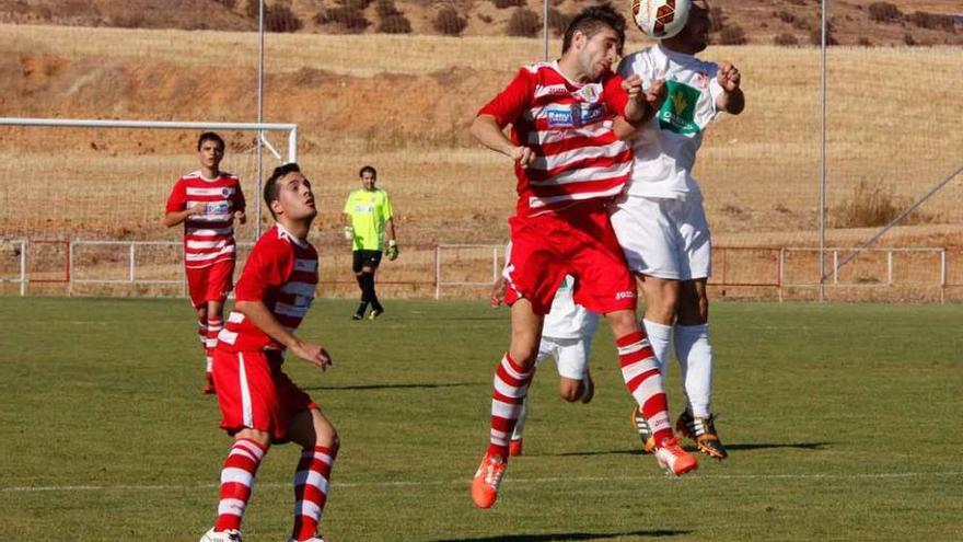 Un jugador del Fresno de la Ribera cabecea el cuero en pugna con un rival.