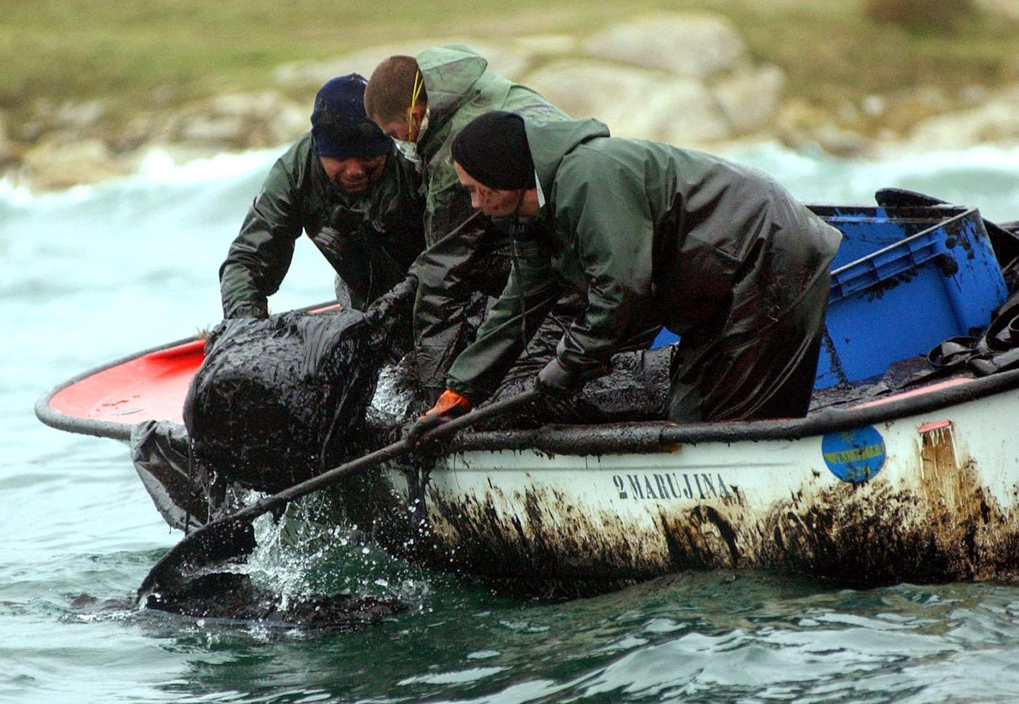 Pescadores recogen el fuel vertido en Aguiño.