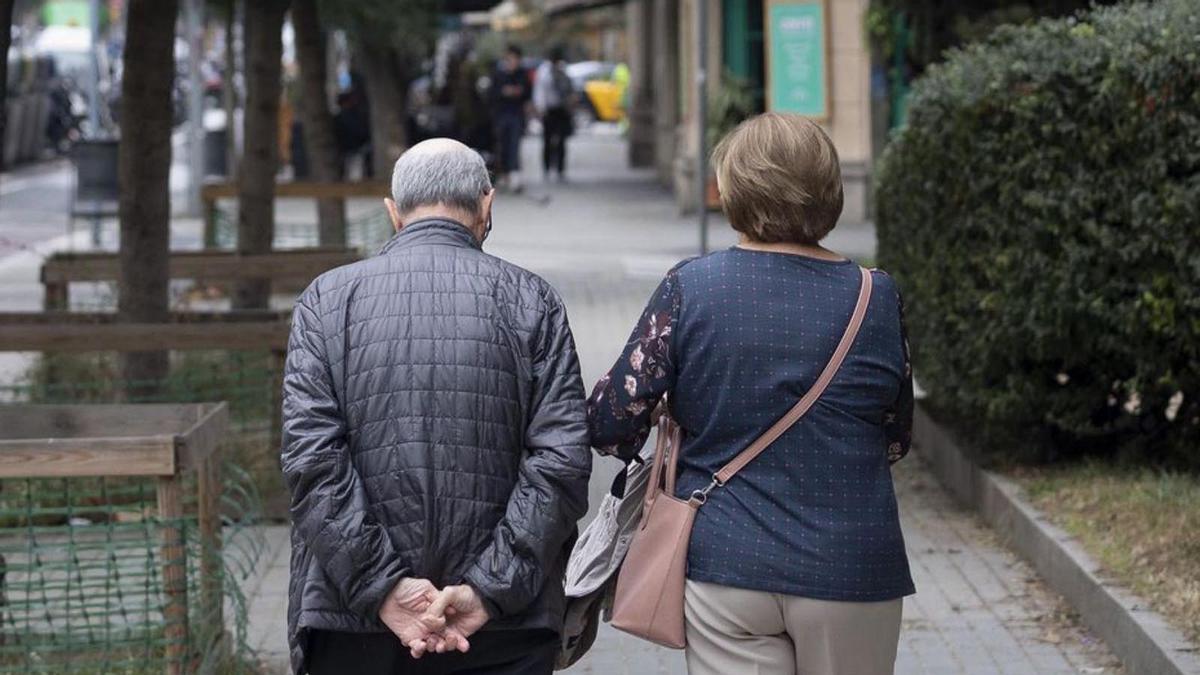 Una parella de jubilats passegen per l’Eixample de Barcelona. | FERRAN NADEU