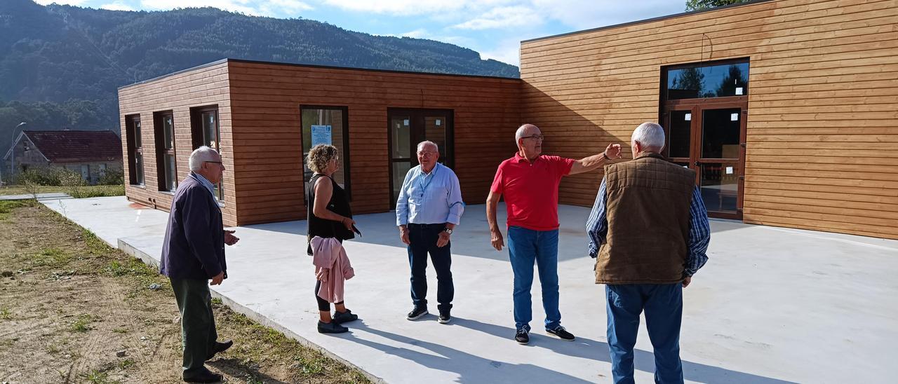 Los miembros de la asociación de vecinos de Quintela, ayer, junto  al nuevo centro sociocultural, aún sin abrir.  // A.P.