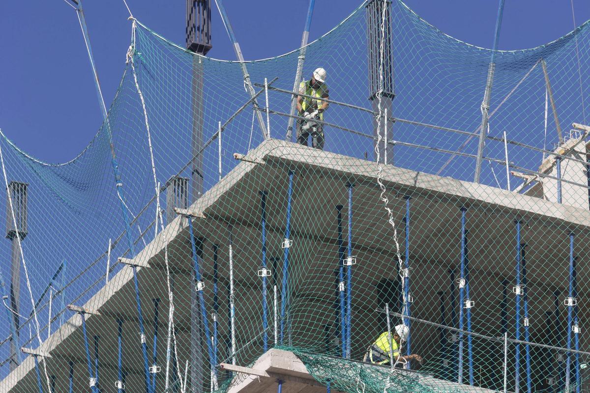 Varios albañiles trabajan en la construcción de un edificio.