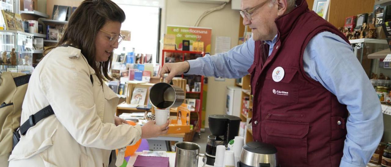 El encargado de la tienda de comercio justo de Zamora sirve un café a una clienta. | JOSE LUIS FERNÁNDEZ