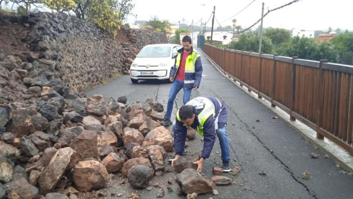 Dos trabajadores retiran piedras en la carretera de Guayadeque, en Ingenio. | | LP/DLP