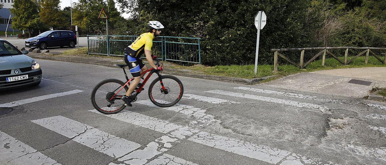 Un ciclista cruza un paso de cebra de la calle Blasco de Garay lleno de baches, con el edificio polivante de la Escuela Politécnica a la izquierda. | Á. González