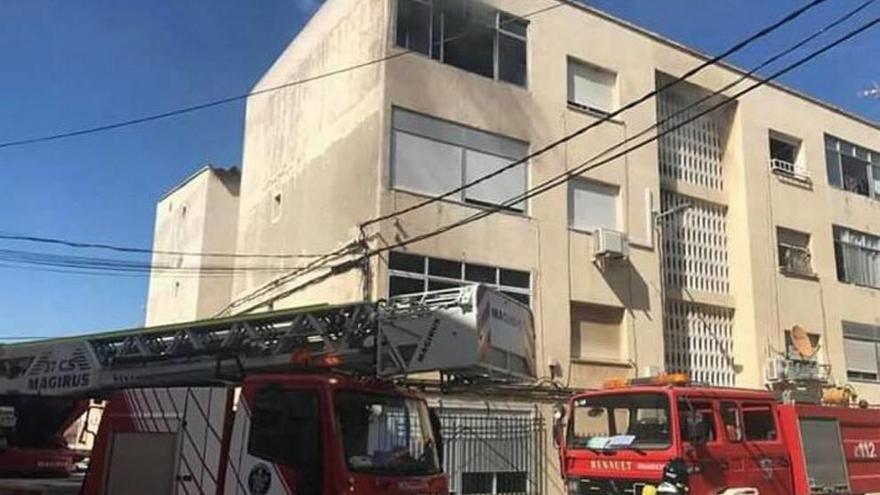 Bomberos en la puerta del edificio siniestrado.