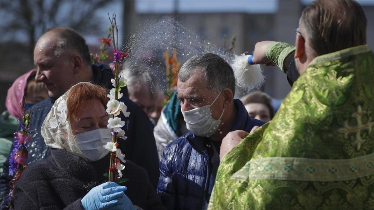 Fieles con másacara en una ceremonia de pascua ortodoxa en Minsk.
