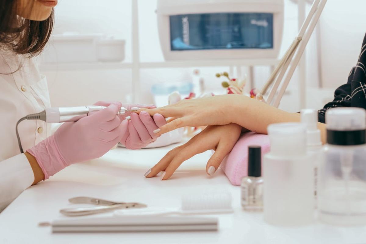 Una mujer le hace la manicura a otra.