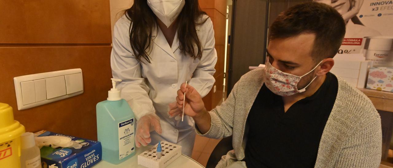 Un joven se realiza un autotest covid en una farmacia de Castellón.