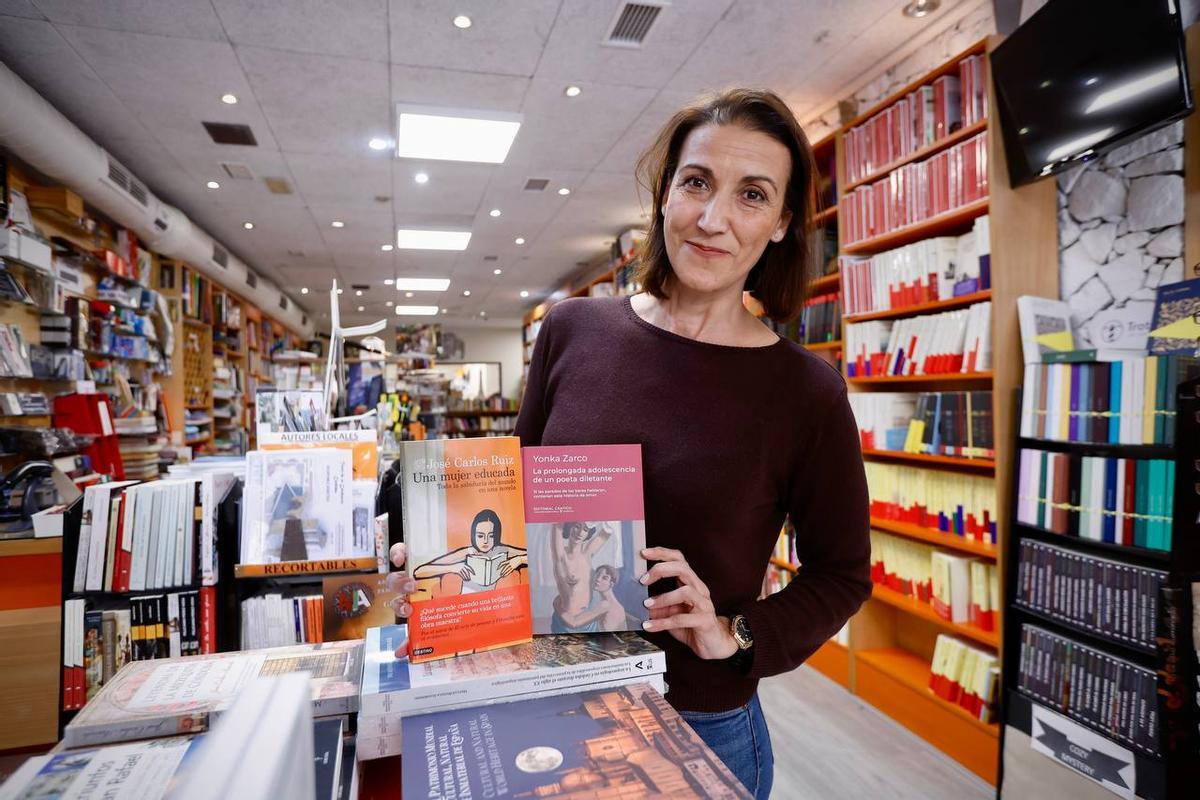 Esther Romero, de la Librería Luque, junto a dos de las obras más solicitadas en la tienda.