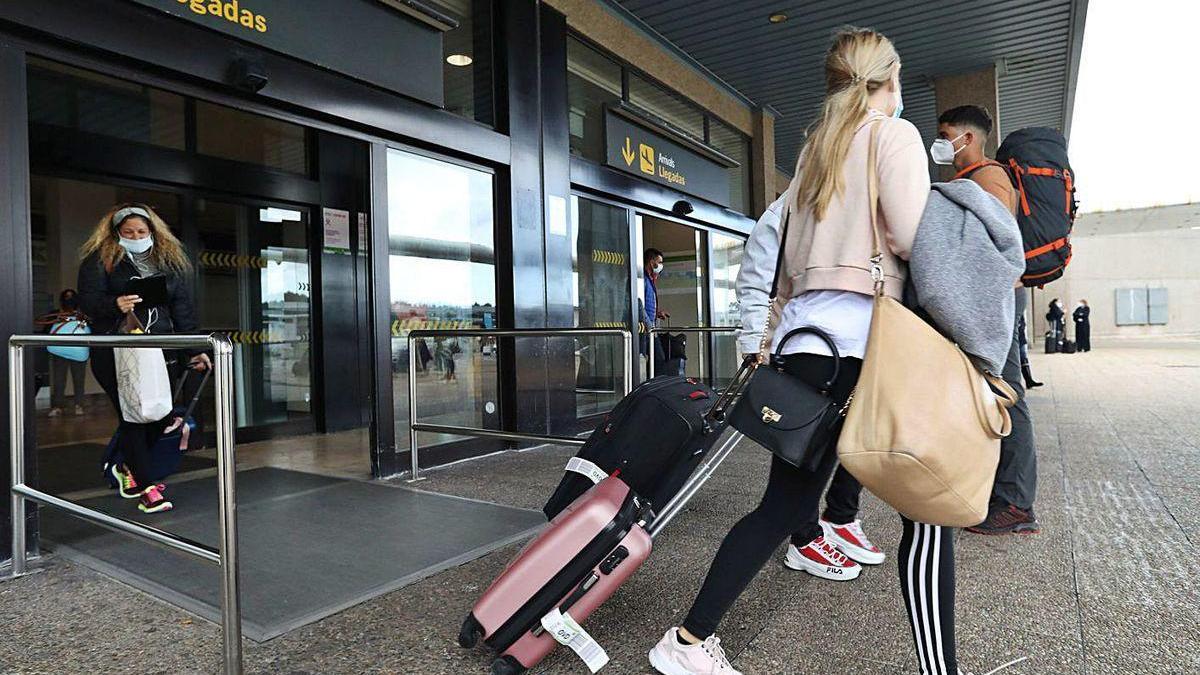 Dos pasajeras del vuelo vespertino de ayer procedente de Madrid abandonan el aeropuerto asturiano.