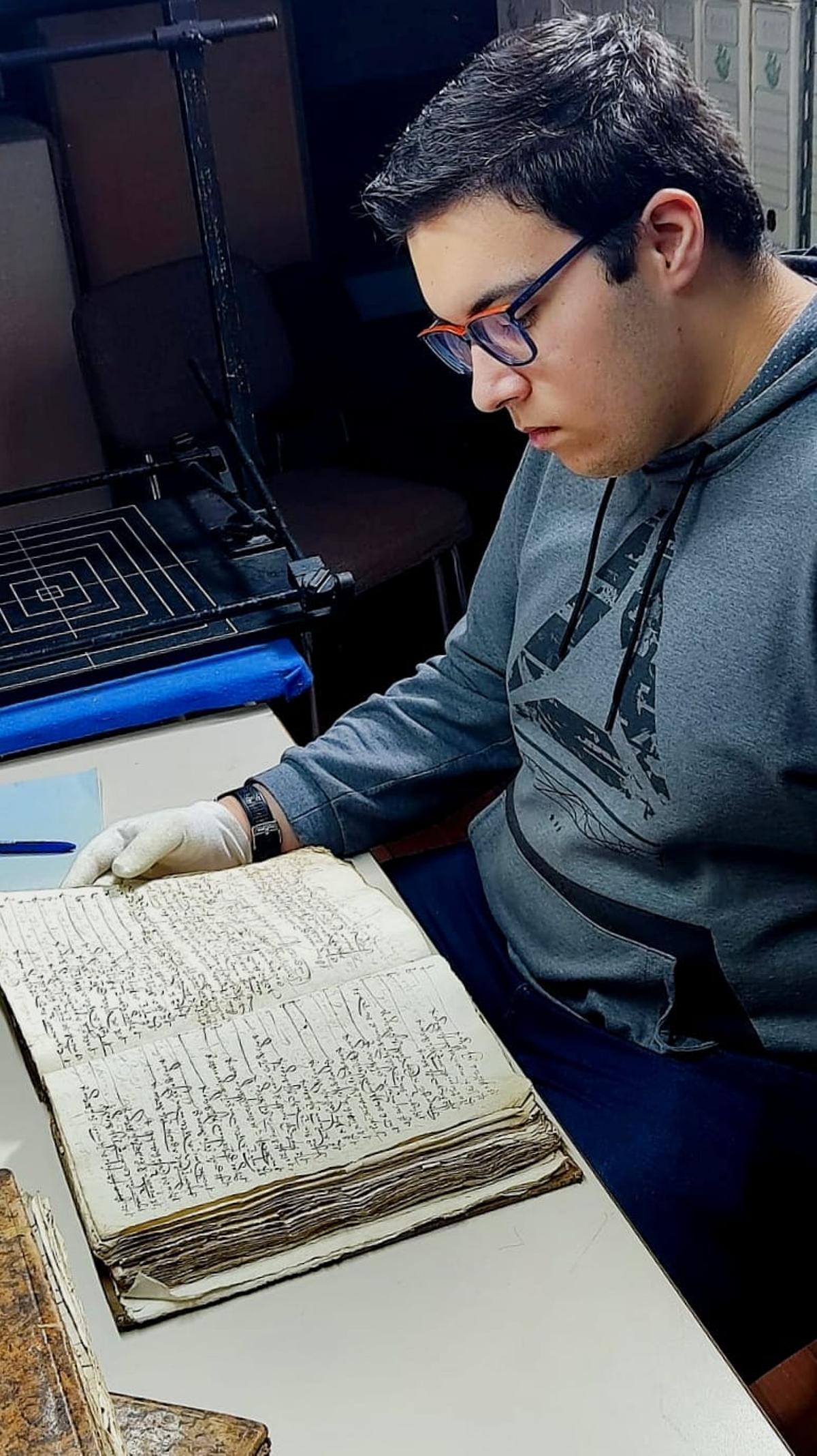 Allonca consultando uno de los documentos del archivo.