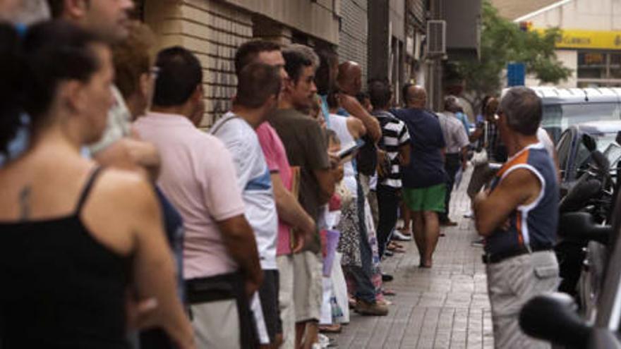 Decenas de personas esperando en la cola de una de las oficina de empleo de Alicante.