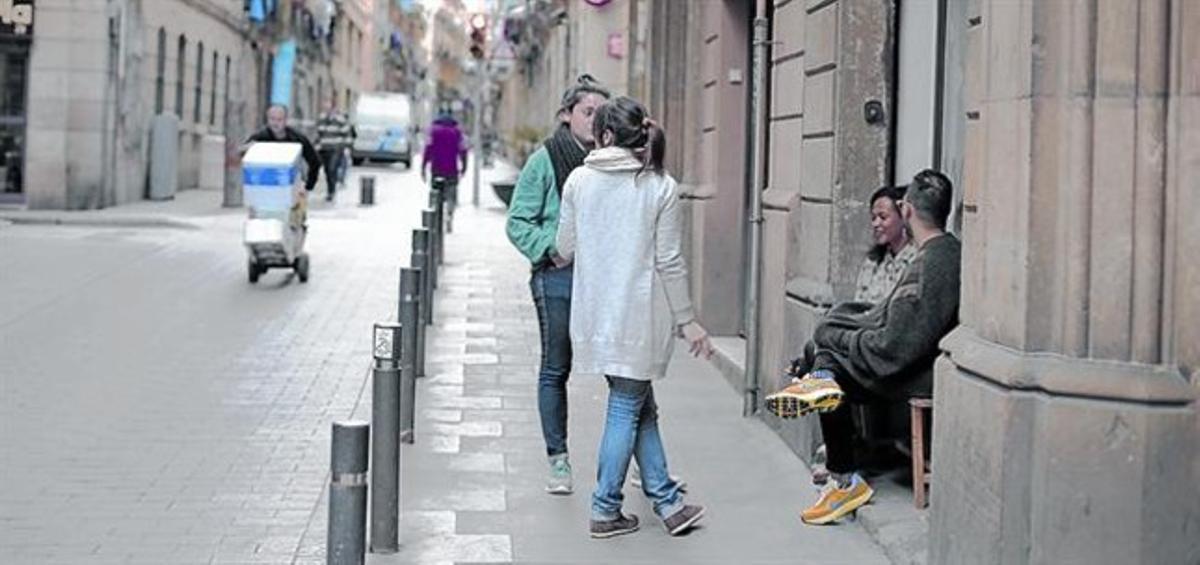 Uns joves descansen als bancs d’una botiga galeria, al carrer de la Lluna, ahir. Uns joves descansen als bancs d’una botiga galeria, al carrer de la Lluna, ahir.