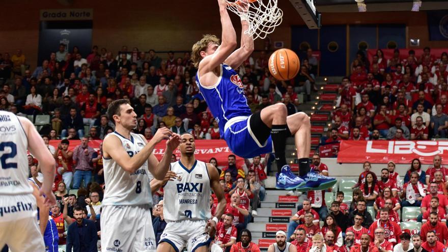 Raieste, de l'UCAM, esmaixa tot sol davant de la mirada dels jugadors de pista i de banqueta del Baxi