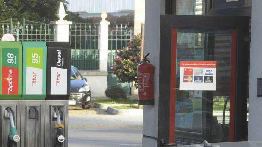 Un empleado de una gasolinera carga combustible en un coche.