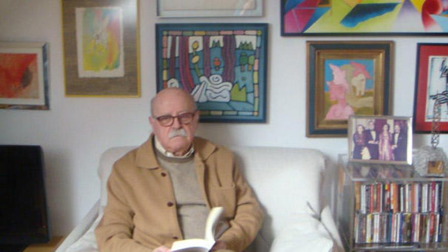 Albino Mallo, uno de estos días en su casa de A Coruña. Al fondo, una foto con su mujer y el cineasta Fernando Rey.