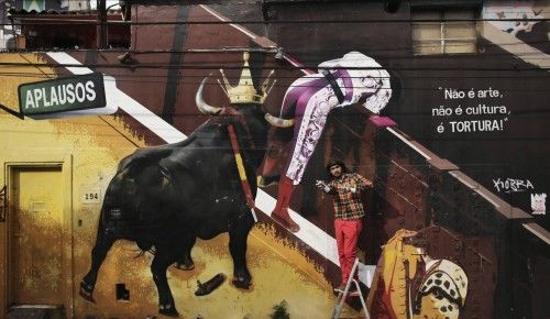 El artista brasileño Eduardo Kobra posa en la entrada de una casa decorada con un mural contra las corridas de toros pintado por él en Sao Paulo
