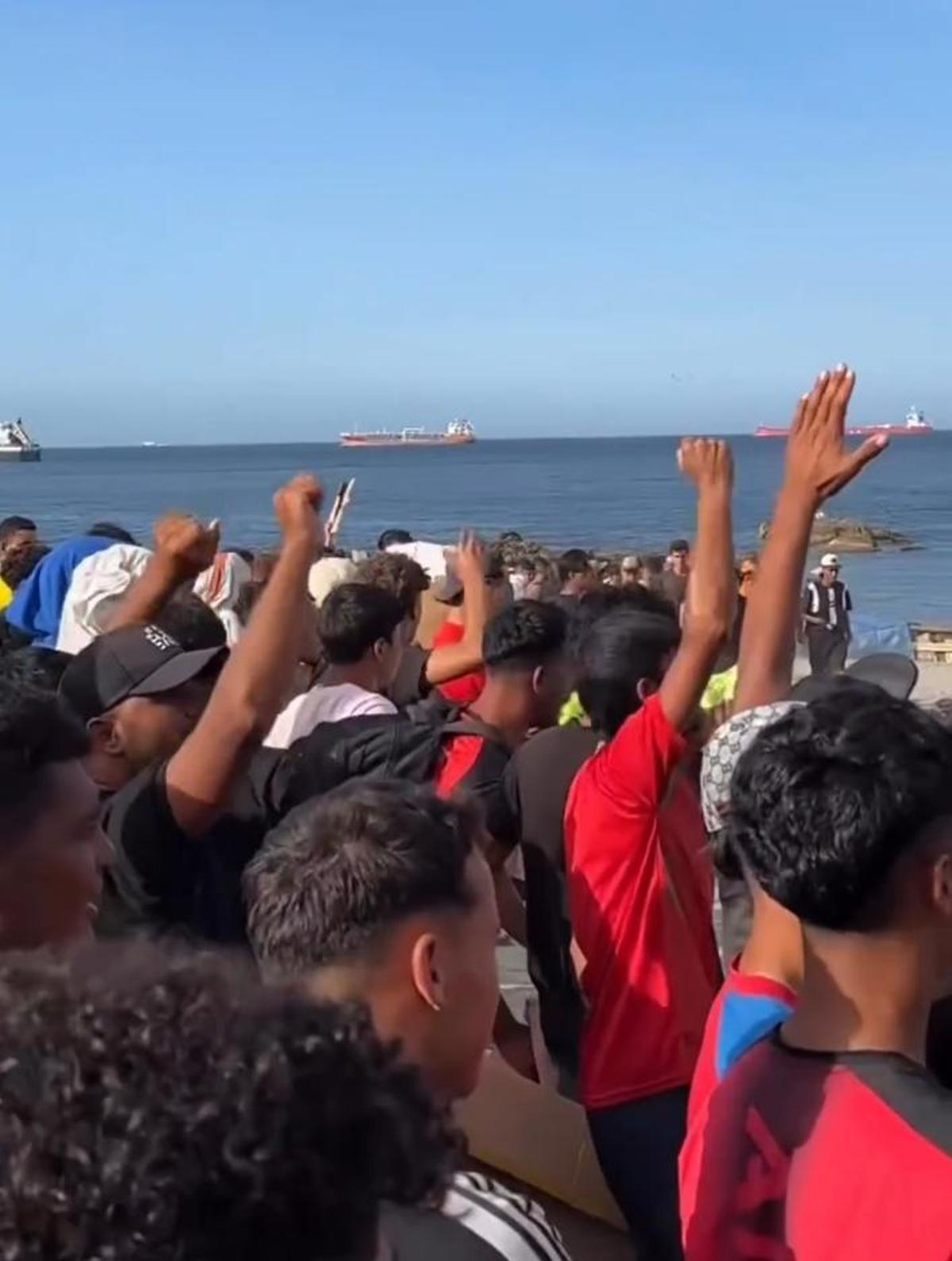 Protesta de migrantes en la playa del Trampolín de Ceuta durante el reparto de comida el 26 de agosto.