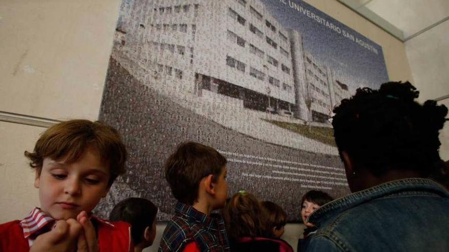 Varios alumnos del colegio Quirinal, ante el mural compuesto por seis mil fotografías.