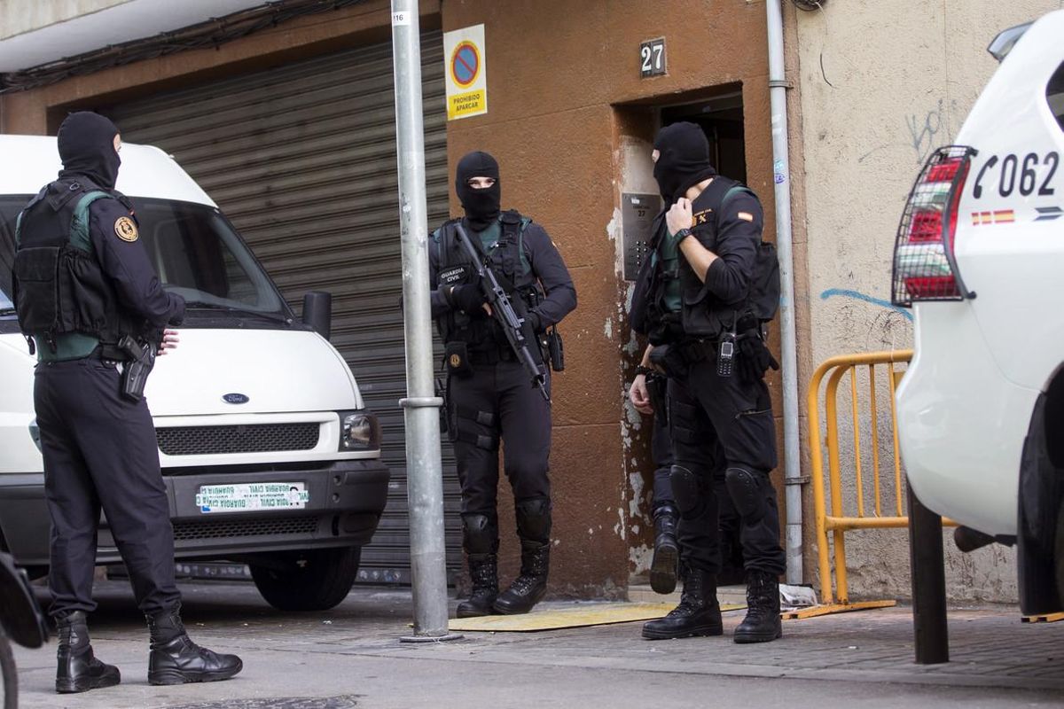 GRA021. BARCELONA, 07/02/2017.- Agentes de la Guardia Civil custodian el acceso al domicilio de uno de los dos ciudadanos marroquíes detenidos hoy en Badalona (Barcelona), acusados de realizar actividades de captación, adoctrinamiento y financiación de yihadistas, llevada a cabo con actividades delictivas con el tráfico de drogas y delitos contra el patrimonio. Ambos pertenecen a un grupo estable de apoyo al Dáesh y, además de consumir y difundir material propagandístico del grupo terrorista, mantenían contacto frecuente con yihadistas que actuaban en zona de conflicto. EFE/Quique García