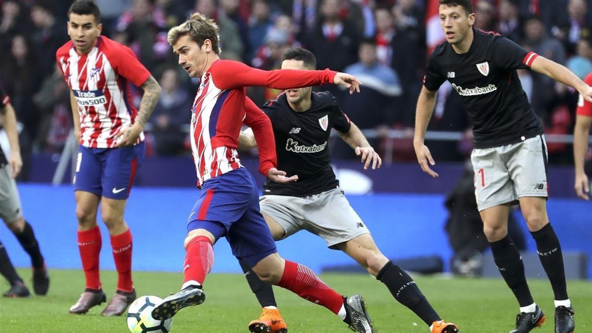 Griezmann controla el balón ante dos rivales del Athletic