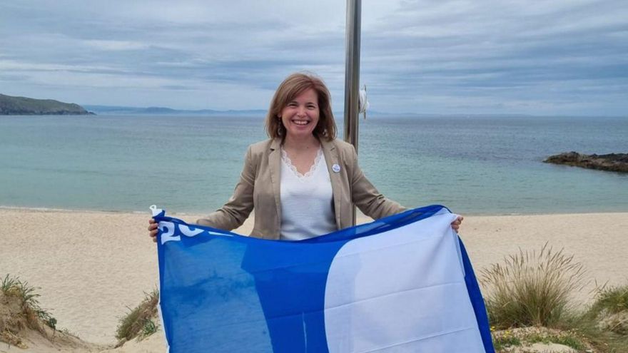 Dolores Chapela con la bandera azul, ayer en Doniños.