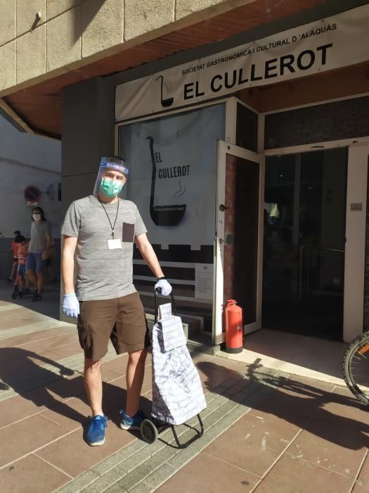 Preparativos y reparto de raciones para cocinar arroz al horno por el voluntariado de "Coronavirus amb Cor" de Alaquàs.