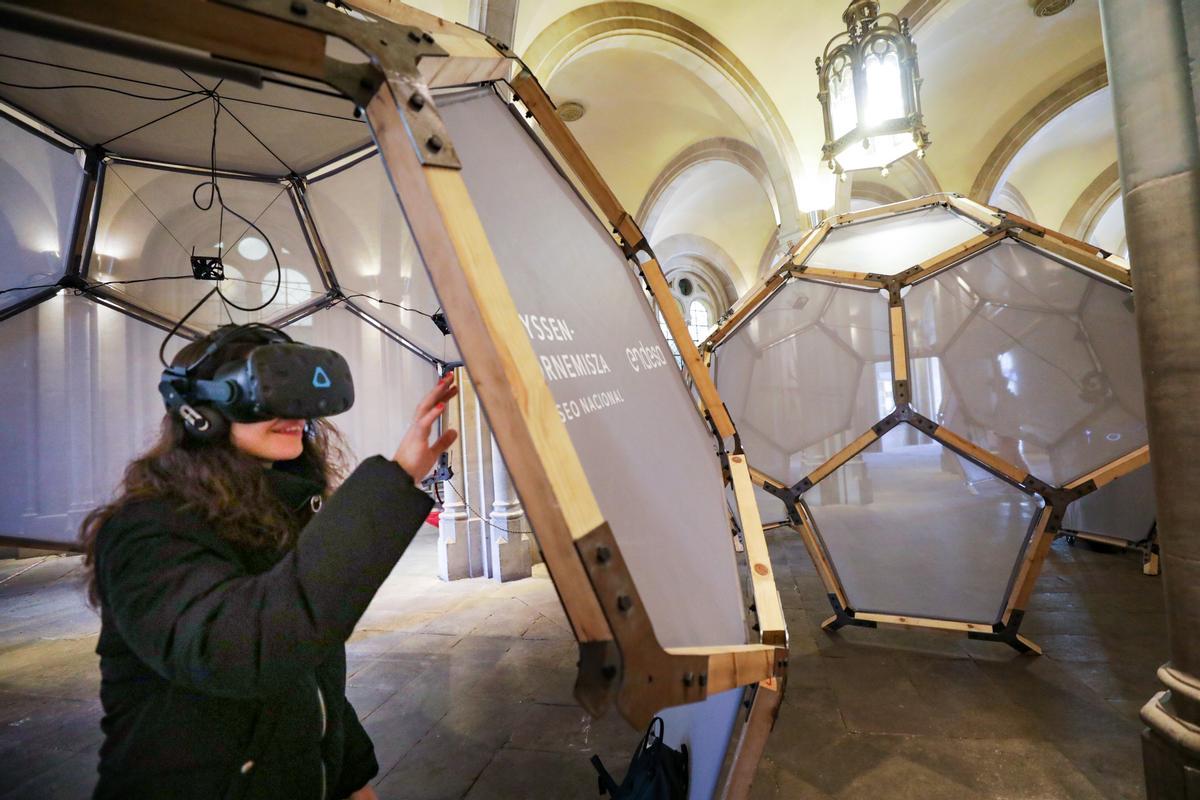 Una joven utiliza un casco de realidad virtual para ver cuadros famosos