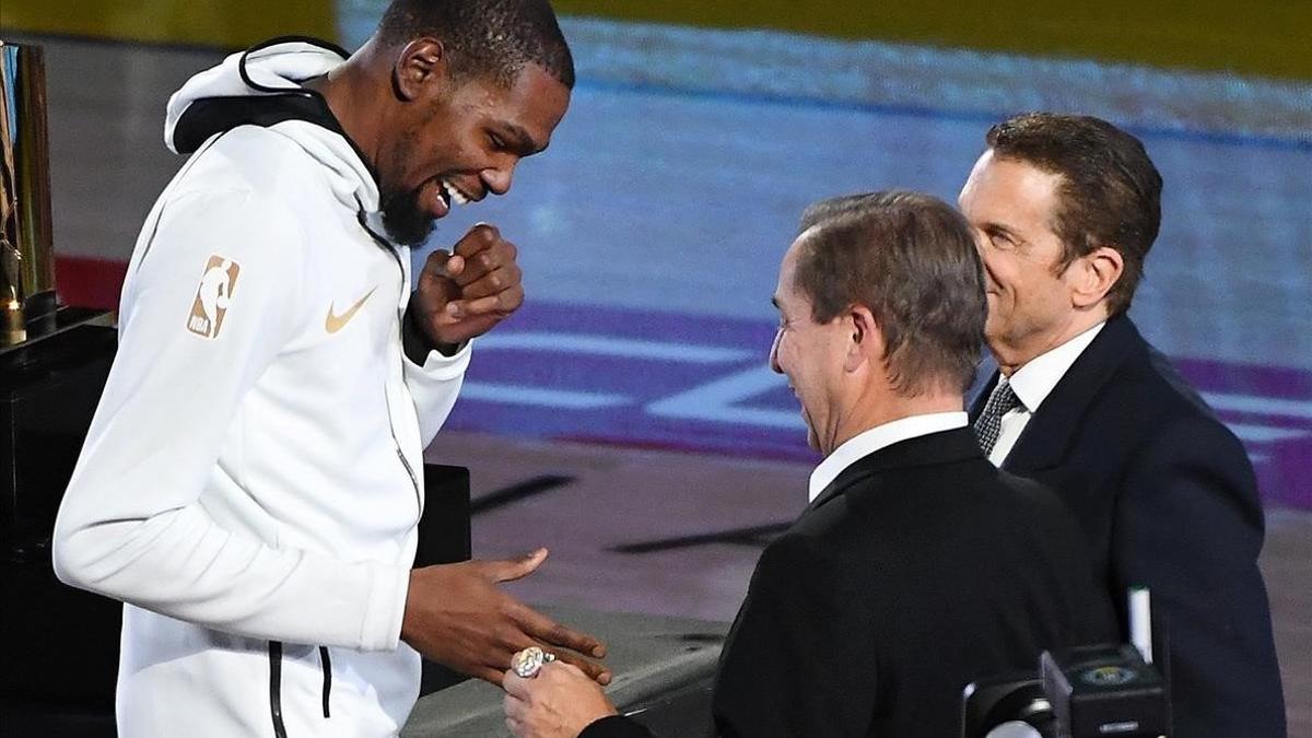Kevin Durant recibe el anillo de campeón de la NBA de manos de Joe Lacob, uno de los propietarios de los Warriors