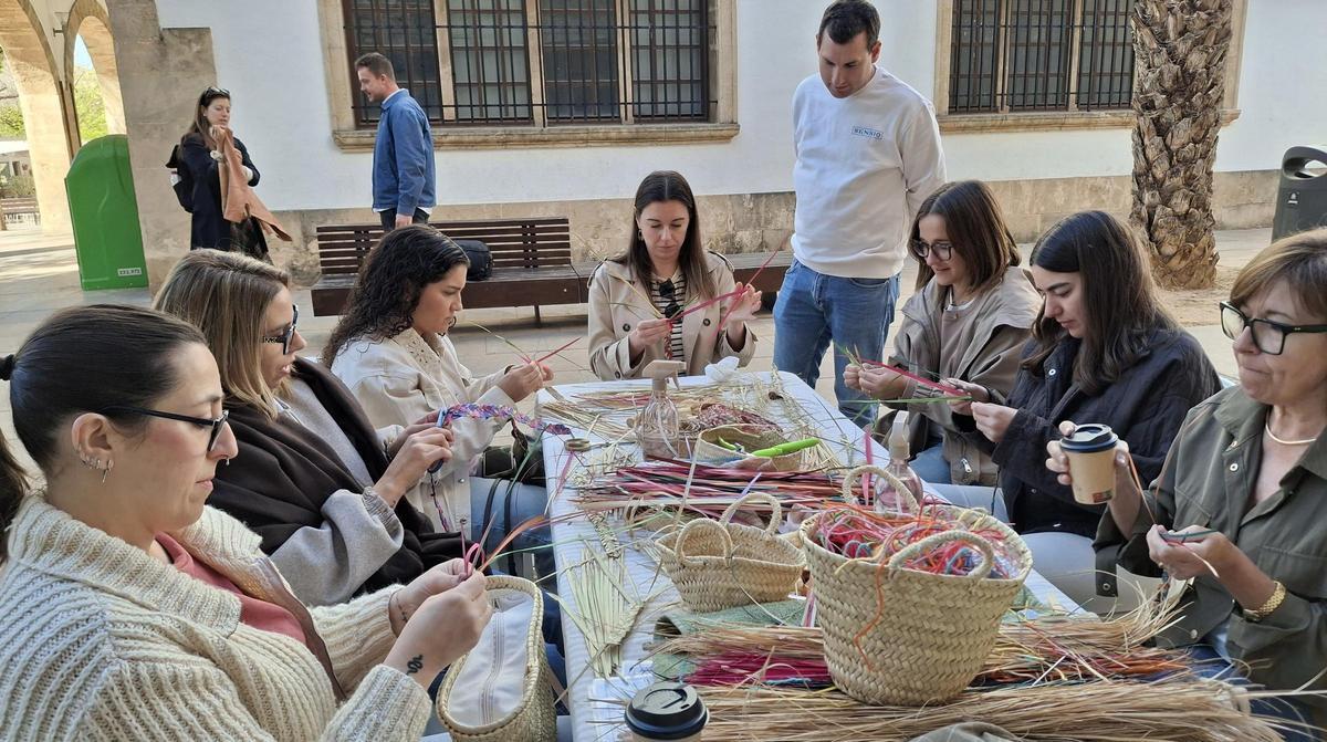 El artesano de Gata de Gorgos observa como sus alumnas trenzan el palmito en un taller en la calle en Xàbia. | A. P. F.
